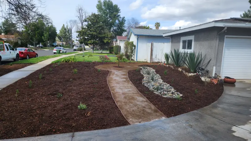 Curved decomposed granite path through freshly mulched beds planted with agaves