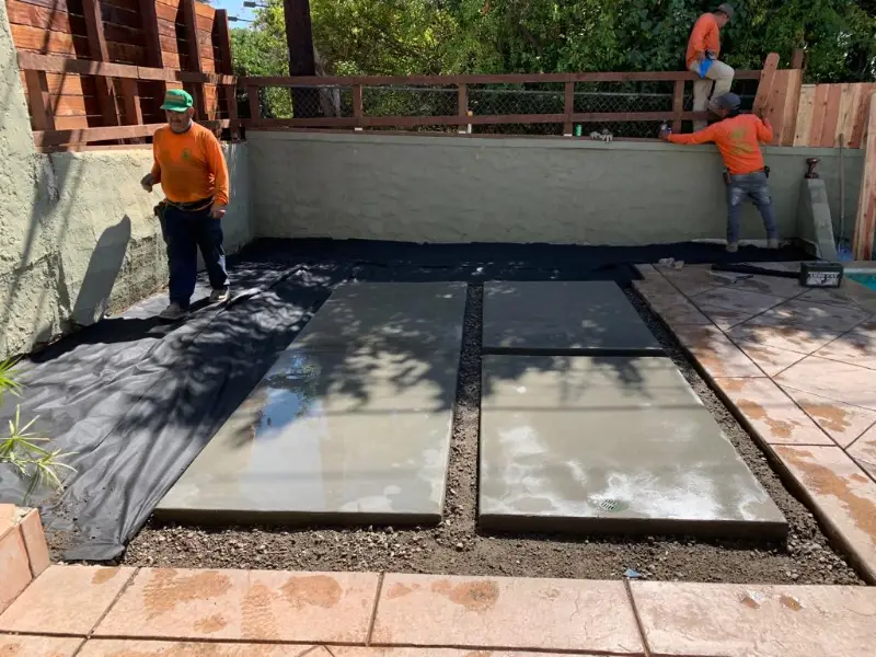 Block wall construction: crew laying the base for a retaining wall and patio